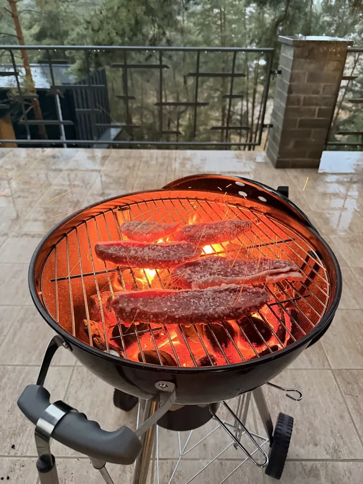 Picanha on a hot barbecue on the terrace among the pines